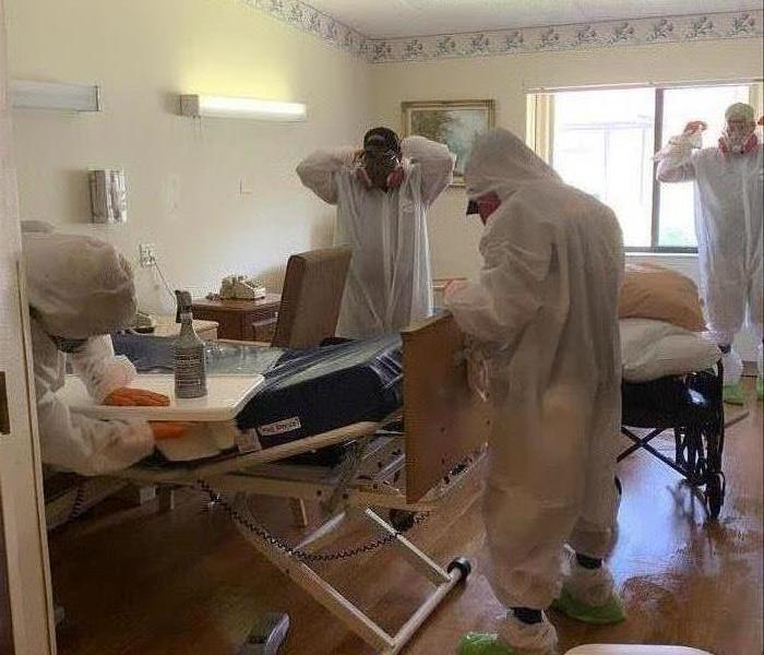 Workers in a hospital room.