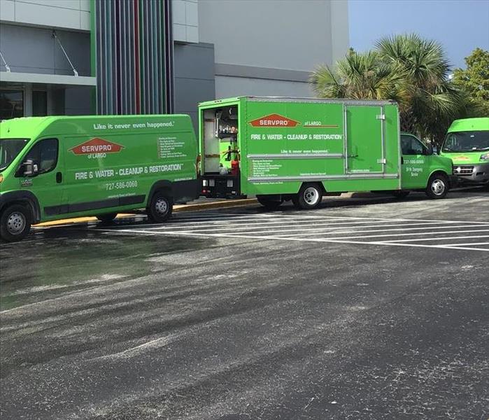 Three SERVPRO trucks in front of a building. 
