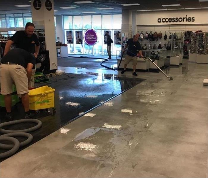 SERVPRO technicians removing standing water from store
