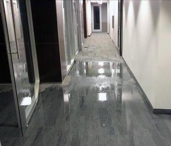 The floors in this hallway are covered in water 