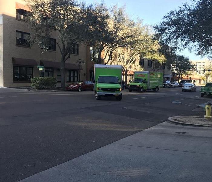 Two SERVPRO vehicles in a turning on a road.